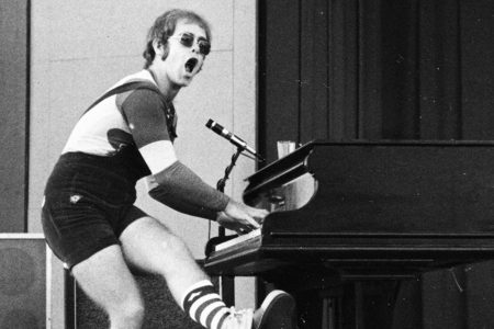 Elton John sentado al piano de cola durante las sesiones de grabación de Blue Moves.