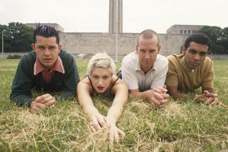 Gwen Stefani en el escenario en los inicios de No Doubt con vestimenta ska y micrófono.