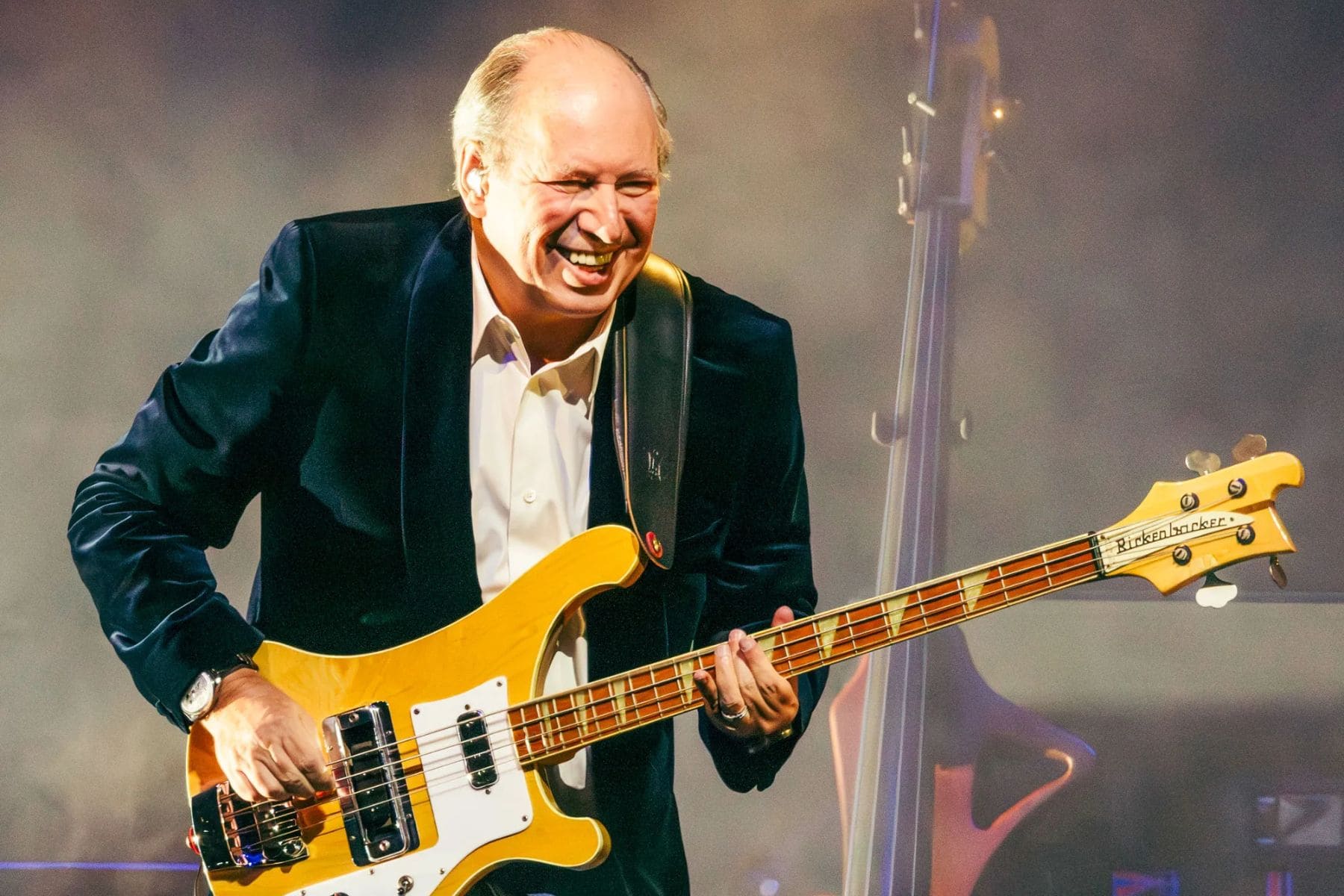 Hans Zimmer tocando la guitarra eléctrica en un escenario junto a su orquesta.