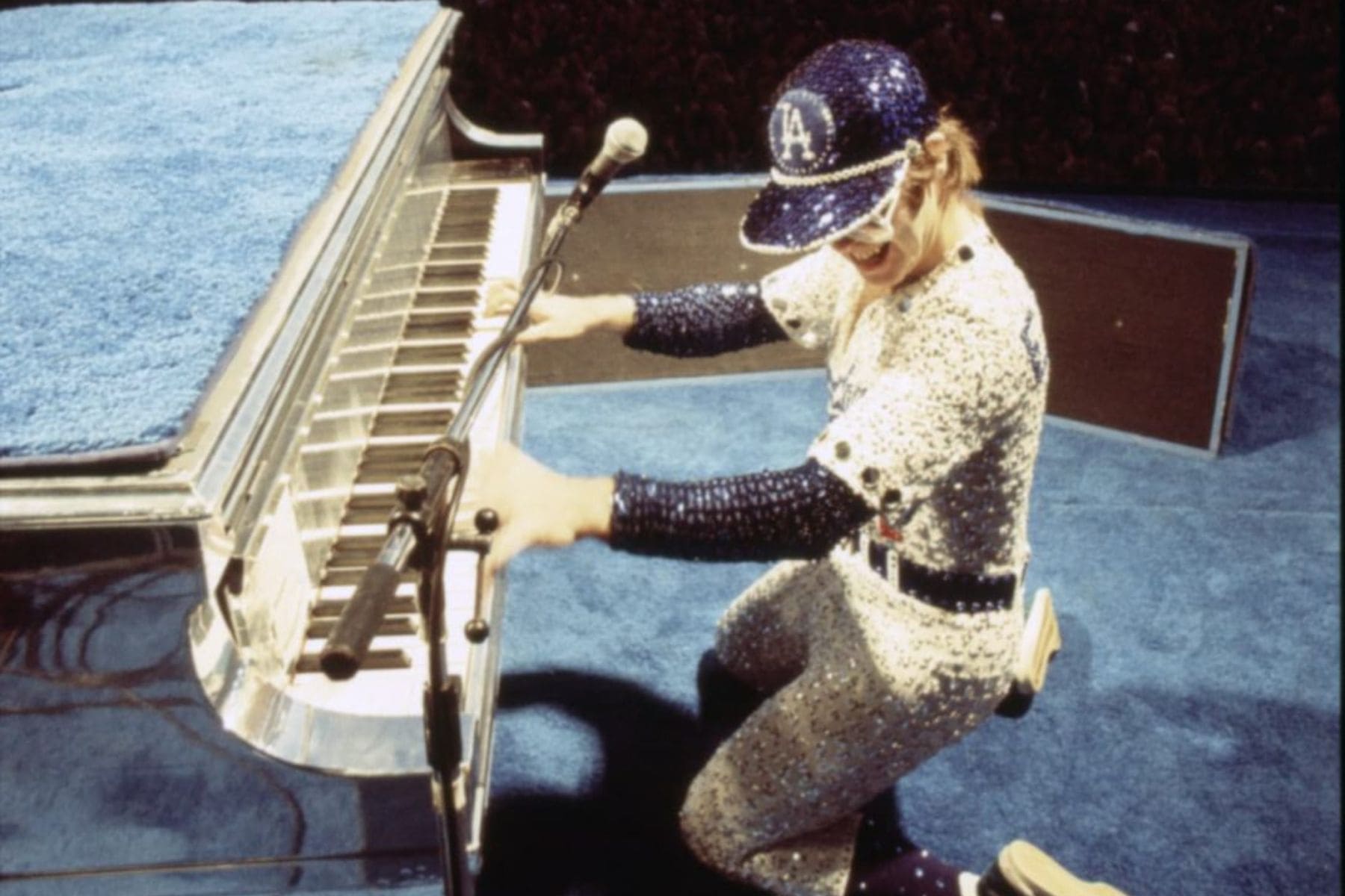 Elton John con el uniforme de béisbol bordado de los Dodgers tocando el piano en 1975.