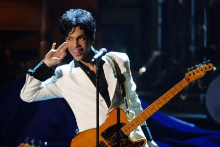 Prince con gabardina y pañuelo al cuello durante la promoción del álbum Dirty Mind