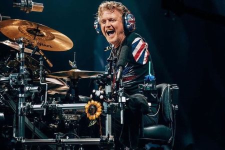 Rick Allen tocando su bateria electronica con pedales descalzo en el escenario