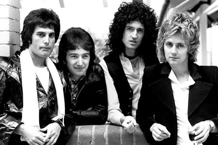 Freddie Mercury cantando con energía en el escenario con Queen.
