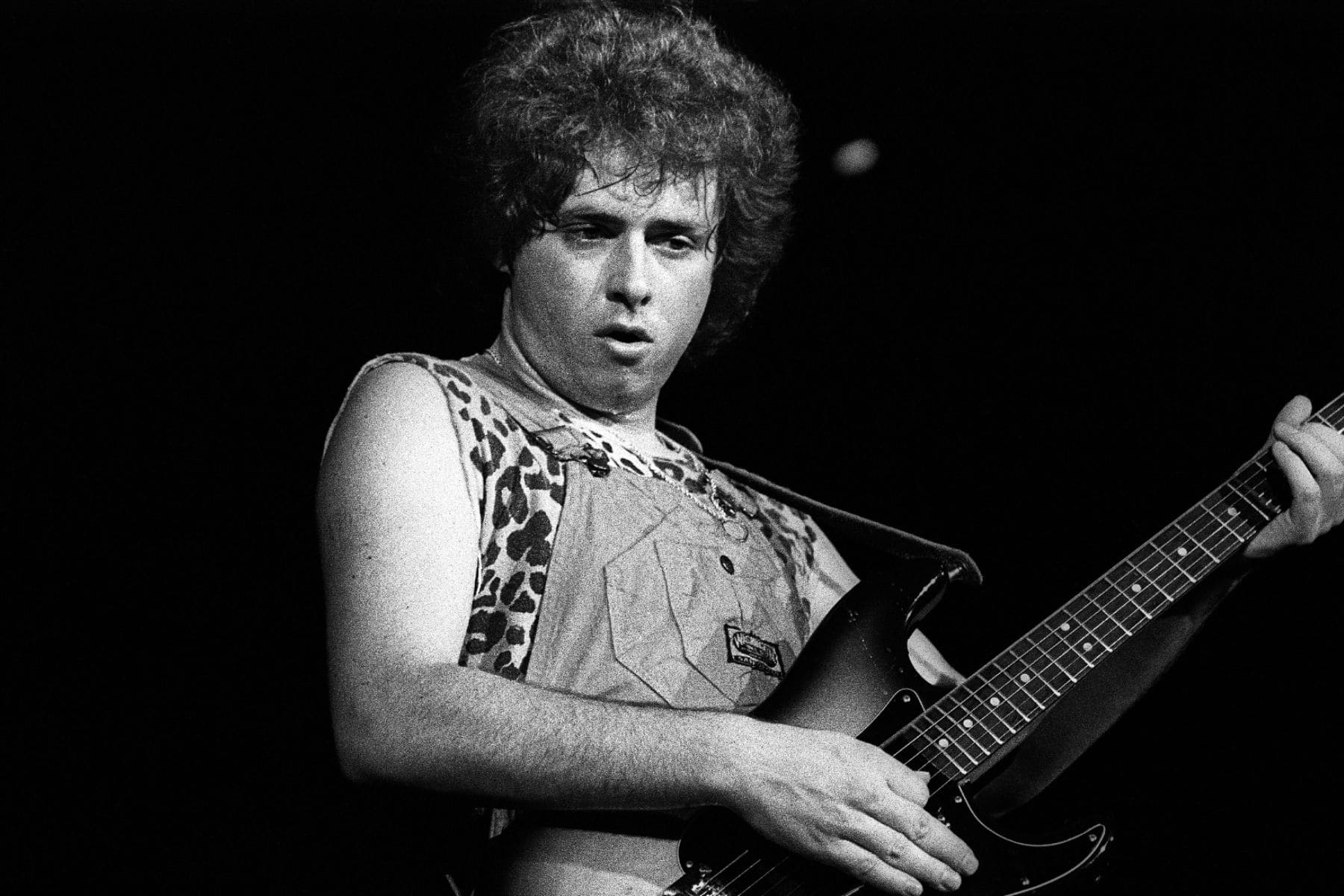 Steve Lukather tocando su guitarra eléctrica con intensidad en el estudio.
