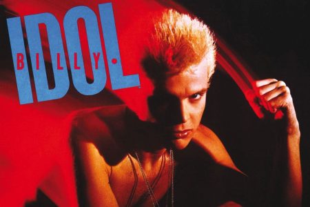 Billy Idol cantando en el escenario con su característico estilo de los ochenta.