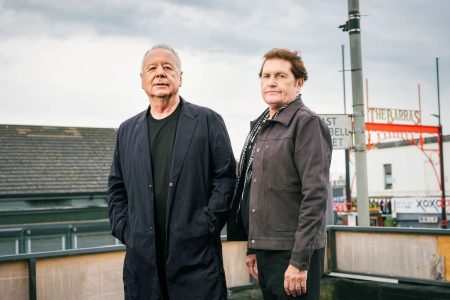 Jim Kerr cantando apasionadamente en un concierto de Simple Minds.