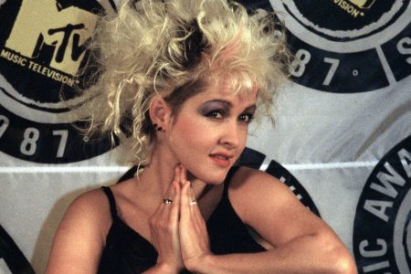 Cyndi Lauper bailando descalza con vestido rojo vintage en la portada del disco Shes So Unusual